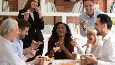 group of coworkers socializing with pizza 