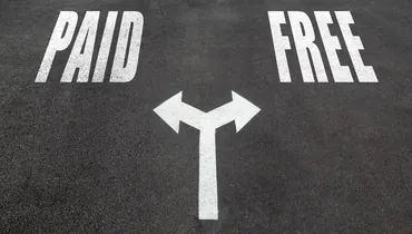 Paid vs free interview concept, two direction arrows on asphalt.
