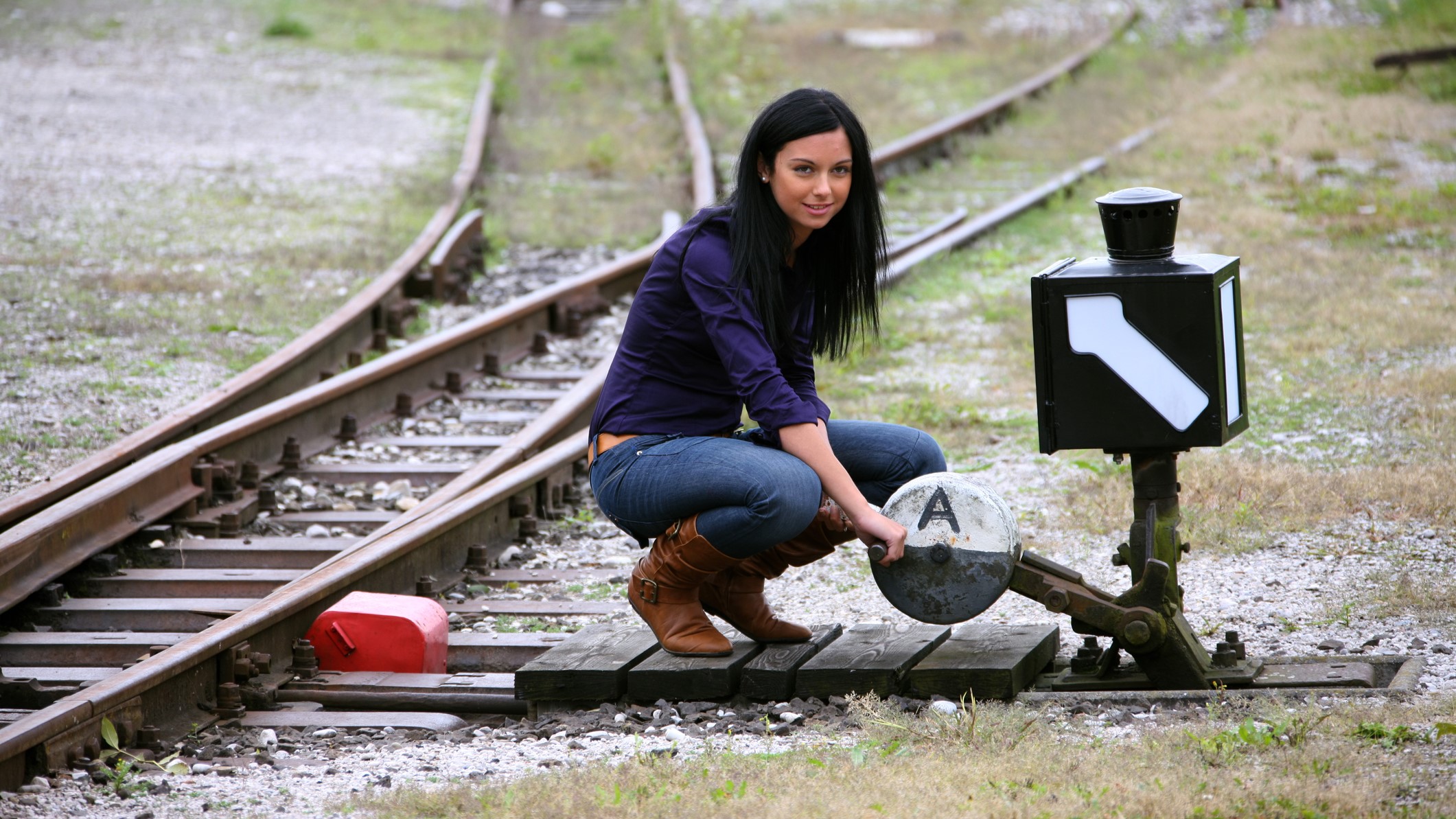Woman with railway junction switch choosing direction symbolizing a career path change